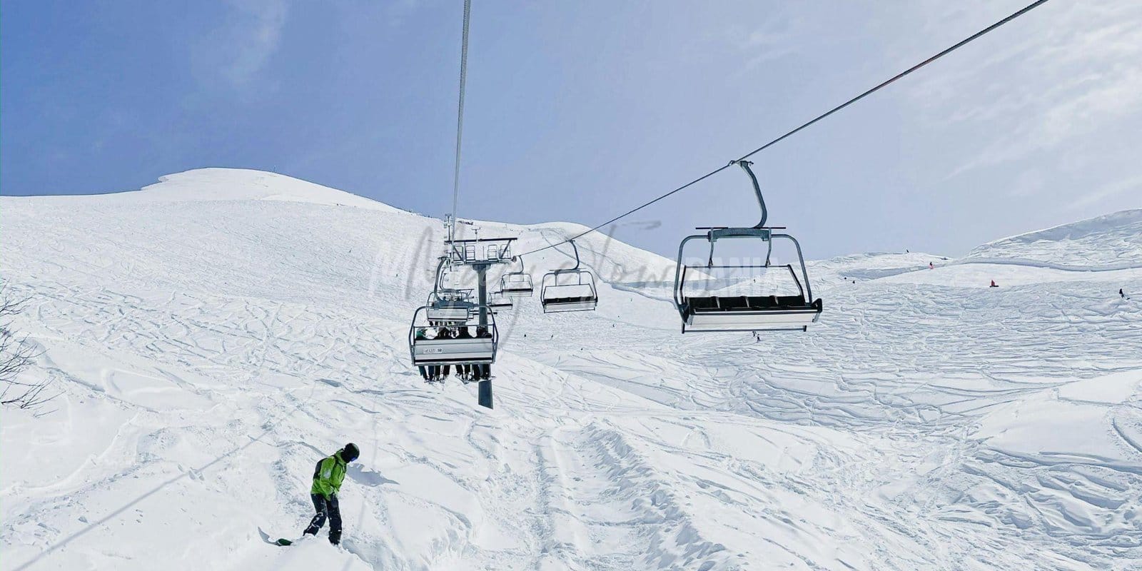 A snowy trail atop a mountain with cable cars in Albania.