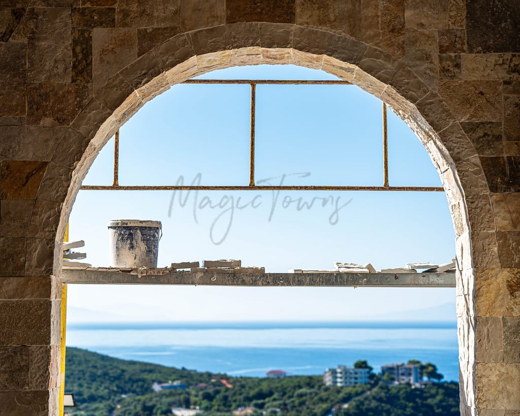 scaffolding outside of stone arches overlooking sea and greenery